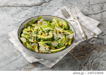 Gourmet salad with shaved asparagus, parmesan, pistachios, avocado and arugula closeup in the plate. Horizontal 140725609