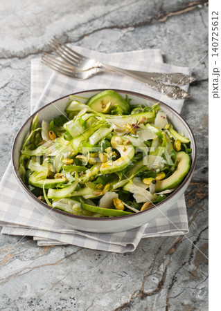 Fresh shaved asparagus salad with pistachios, parmesan cheese, avocado, arugula closeup in the plate. Vertical Fresh shaved asparagus salad with pistachios, parmesan cheese, avocado, arugula closeup in the plate. Vertical 140725612