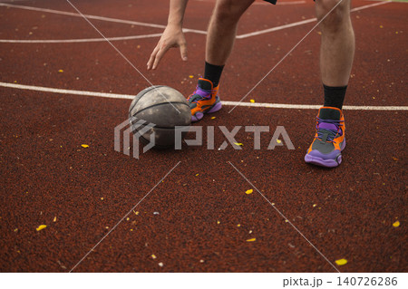 Close up of basketball player dribbling ball on court Close up of basketball player dribbling ball on court 140726286