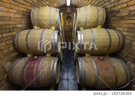 Wine barrels aging in a traditional brick cellar 140726364