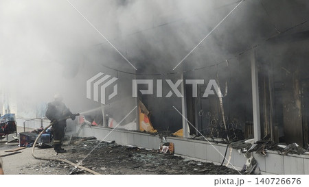 Firefighters extinguish a burning store. Fire and smoke in a house and insurance. 140726676
