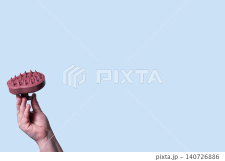 Pink silicone scalp massager in woman hand mockup. Hair brushing and massage. Isolated image for design Pink silicone scalp massager in woman hand mockup. Hair brushing and massage. Isolated image for design 140726886