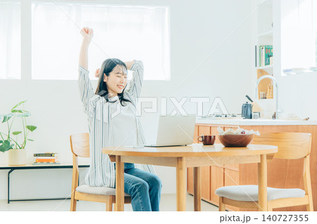 リビングで伸びをする若い女性 リビングで伸びをする若い女性 140727355