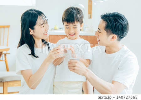 リビングで水を飲む若い家族 140727365