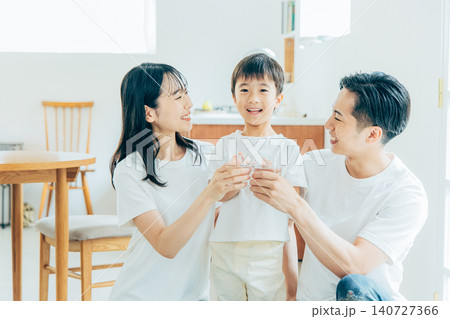 リビングで水を飲む若い家族 リビングで水を飲む若い家族 140727366