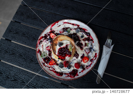 Traditional cottage cheese pancakes syrniki with sour cream and berries close up Traditional cottage cheese pancakes syrniki with sour cream and berries close up 140728677