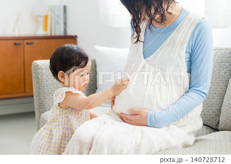 1歳の女の子を抱っこする妊婦のお母さん 140728712