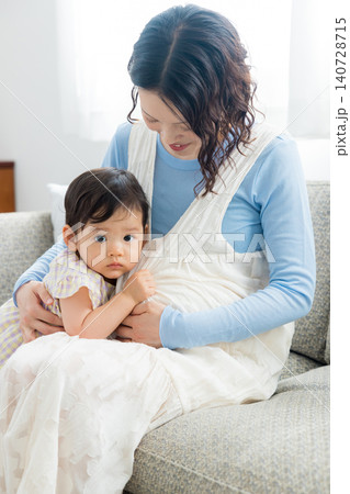 1歳の女の子を抱っこする妊婦のお母さん 140728715