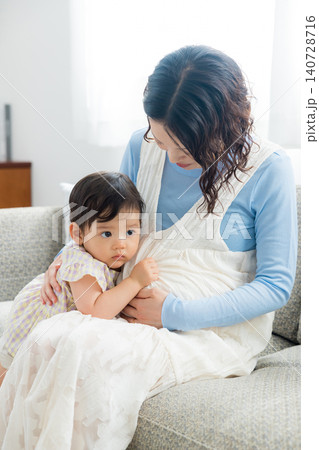 1歳の女の子を抱っこする妊婦のお母さん 1歳の女の子を抱っこする妊婦のお母さん 140728716