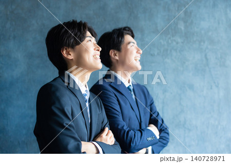 腕組みをするスーツ姿の男性 140728971
