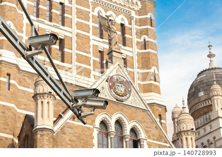 Mumbai Maharashtra India Jan 18 2026 Modern white CCTV surveillance cameras mounted on a metal arm overlooking the historic facade and ornate carvings of the BMC building. 140728993