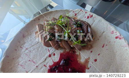 Roasted duck breast fillet with berry sauce on a white plate Roasted duck breast fillet with berry sauce on a white plate 140729223