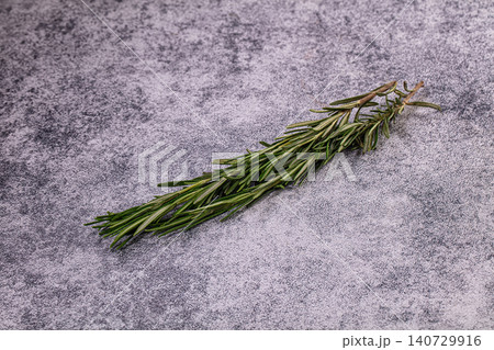 Aromatic green rosemary sprig on textured grey background 140729916