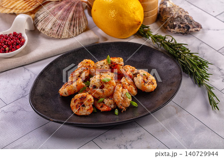 Gourmet grilled shrimp with green onion garnish on dark plate Gourmet grilled shrimp with green onion garnish on dark plate 140729944