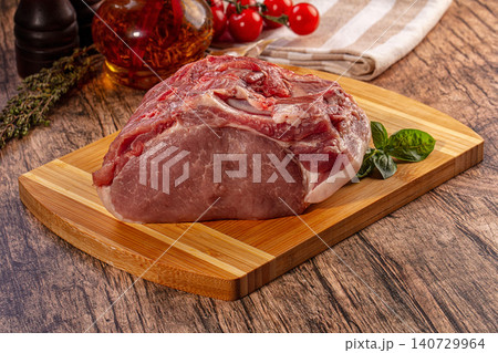 Raw pork loin on wooden board with herbs and tomatoes for cooking 140729964