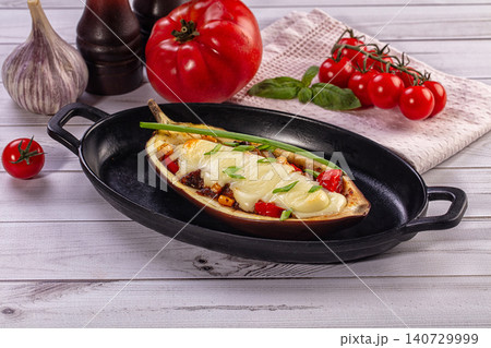 Stuffed eggplant with cheese and vegetables in cast iron skillet Stuffed eggplant with cheese and vegetables in cast iron skillet 140729999