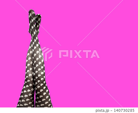 Female legs in heart pattern tights on bright background in fashion concept. Stylish hosiery design with playful aesthetic and bold color. Concept of modern clothing style.. Female legs in heart pattern tights on bright background in fashion concept. Stylish hosiery design with playful aesthetic and bold color. Concept of modern clothing style.. 140730285