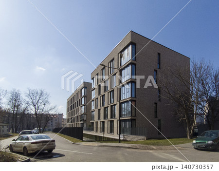 Modern residential building in constructivism style with clean geometric facade. Apartment structure shows minimal design and urban composition Modern residential building in constructivism style with clean geometric facade. Apartment structure shows minimal design and urban composition 140730357