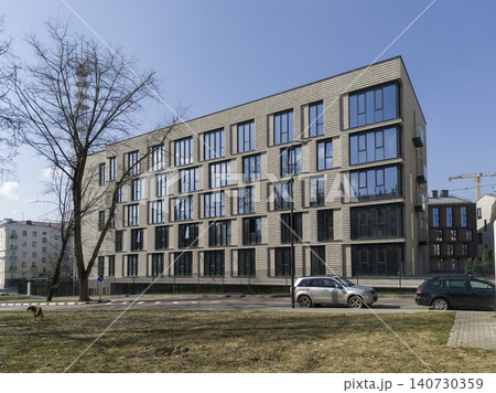 Modern residential building with extended facade and geometric layout in urban area. Apartment structure shows linear composition and clean design. Concept of contemporary housing Modern residential building with extended facade and geometric layout in urban area. Apartment structure shows linear composition and clean design. Concept of contemporary housing 140730359