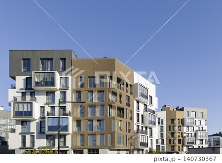 Modern residential buildings with balconies forming urban architectural composition. Apartment complex shows geometric layout and clean facade lines. Concept of contemporary housing 140730367