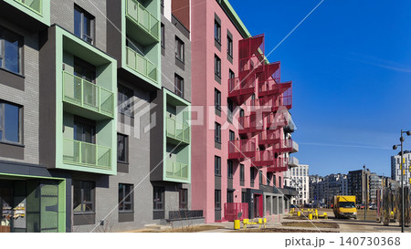 Modern residential buildings with colorful facade and geometric balcony design. Apartment structures form urban composition with clear sky background. Concept of contemporary housing Modern residential buildings with colorful facade and geometric balcony design. Apartment structures form urban composition with clear sky background. Concept of contemporary housing 140730368