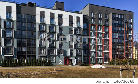Modern residential buildings with contrasting facade colors and geometric layout. Apartment structures create urban composition with clean lines. Concept of contemporary housing development Modern residential buildings with contrasting facade colors and geometric layout. Apartment structures create urban composition with clean lines. Concept of contemporary housing development 140730369