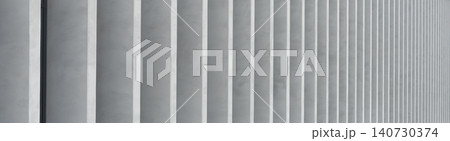 Panoramic architectural background with repeating concrete elements forming pattern. Horizontal composition of minimal facade detail in gray tones. Concept of modern design texture abstract 140730374