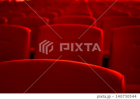 Close up of red theatre chair. Empty red seats in the theatre. Patterns of chairs in a theater. Seats background pattern photo.  140730544