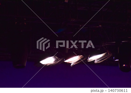 Set of professional stage lighting equipment on the stage for gig illumination of theater or concert hall. Stage lights, spotlights and laser beams. Rays of light from the floodlights. Concert light. 140730611