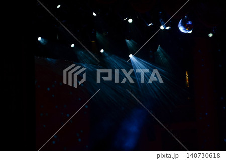 Set of professional stage lighting equipment on the stage for gig illumination of theater or concert hall. Stage lights, spotlights and laser beams. Rays of light from the floodlights. Concert light. 140730618