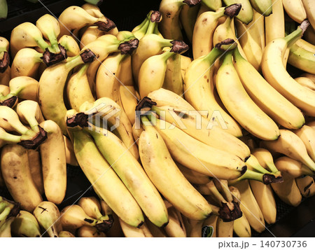 Close up of fresh bananas in bunches on display at a fruit market or grocery store. Close up of fresh bananas in bunches on display at a fruit market or grocery store. 140730736