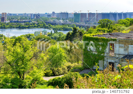 View of city skyline by the river with greenery and old building in the foreground during a sunny day View of city skyline by the river with greenery and old building in the foreground during a sunny day 140731792