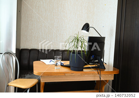 Workspace with laptop, notebook, and papers on bed during the afternoon in a simple room setting Workspace with laptop, notebook, and papers on bed during the afternoon in a simple room setting 140732052
