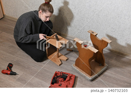 woman fixing a chair with staple woman fixing a chair with staple 140732103