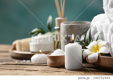 Beautiful spa composition with plumeria flower on wooden table, closeup Beautiful spa composition with plumeria flower on wooden table, closeup 140732443