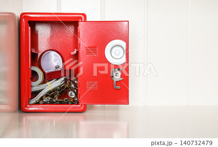 Open red steel safe with money and jewelry on shelf. Space for text Open red steel safe with money and jewelry on shelf. Space for text 140732479