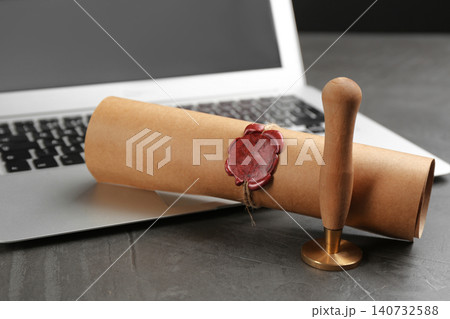 Notary's public pen and sealed document near laptop on grey stone table, closeup Notary's public pen and sealed document near laptop on grey stone table, closeup 140732588