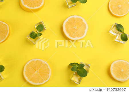 Lemonade layout with juicy lemon slices, ice and mint on yellow background, top view Lemonade layout with juicy lemon slices, ice and mint on yellow background, top view 140732607