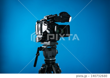 Modern professional video camera on blue background 140732680