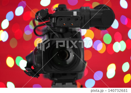 Modern video camera against blurred colorful lights 140732681