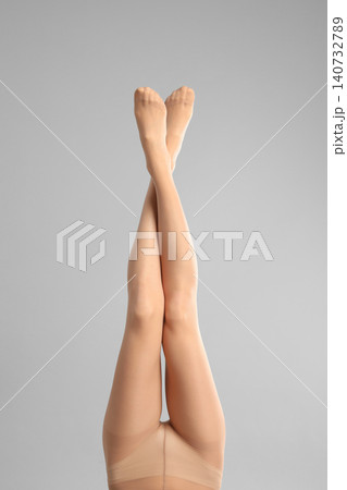 Woman wearing tights on light grey background, closeup of legs 140732789