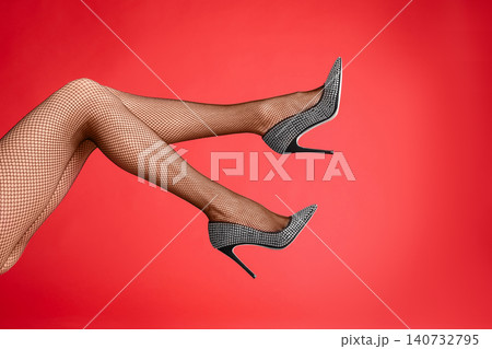 Woman wearing black tights and stylish shoes on red background, closeup of legs Woman wearing black tights and stylish shoes on red background, closeup of legs 140732795