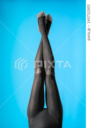 Woman wearing black tights and stylish shoes on blue background, closeup of legs Woman wearing black tights and stylish shoes on blue background, closeup of legs 140732805