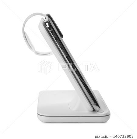 Mobile phone and smartwatch charging with wireless pad isolated on white Mobile phone and smartwatch charging with wireless pad isolated on white 140732905