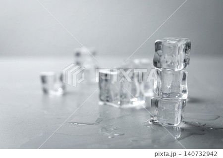 Crystal clear ice cubes with water drops on grey table. Space for text Crystal clear ice cubes with water drops on grey table. Space for text 140732942