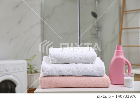 Clean towels and detergents on table in laundry room 140732970
