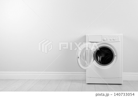 Modern washing machine near white wall, space for text. Laundry day Modern washing machine near white wall, space for text. Laundry day 140733054