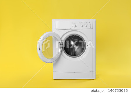 Modern washing machine on yellow background. Laundry day Modern washing machine on yellow background. Laundry day 140733056
