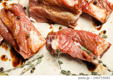 Raw marinated ribs with thyme and peppercorn, closeup Raw marinated ribs with thyme and peppercorn, closeup 140733085