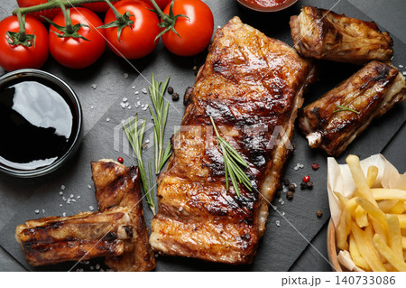Delicious grilled ribs on black table, flat lay Delicious grilled ribs on black table, flat lay 140733086